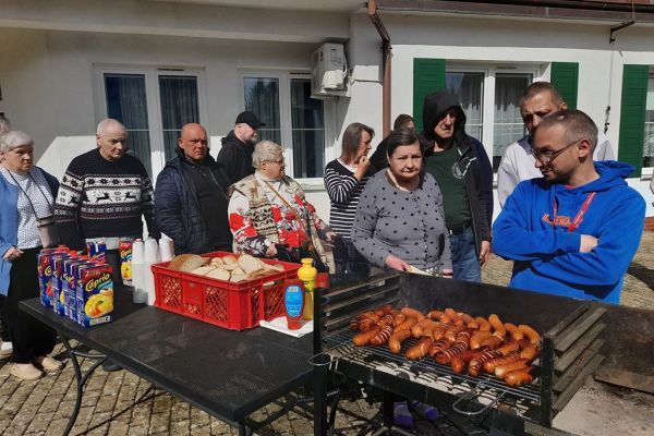 Mieszkańcy korzystają z grilla na tarasuie,tańczą,  grają w kręgle , częstują się kiełbaska