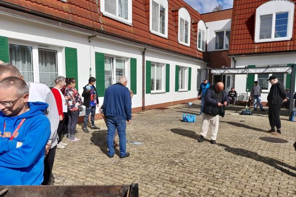 Mieszkańcy korzystają z grilla na tarasuie,tańczą,  grają w kręgle , częstują się kiełbaska