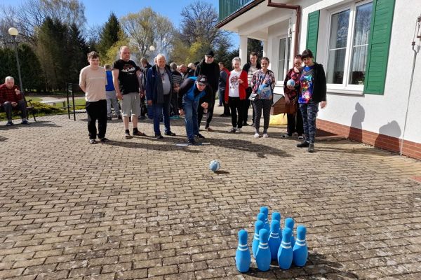 Mieszkańcy korzystają z grilla na tarasuie,tańczą,  grają w kręgle , częstują się kiełbaska