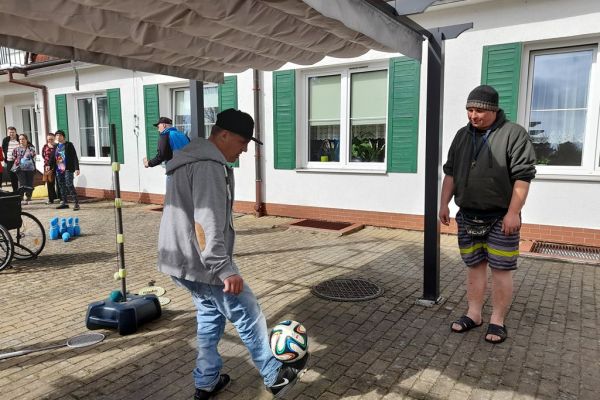 Mieszkańcy korzystają z grilla na tarasuie,tańczą,  grają w piłkę , częstują się kiełbaską.