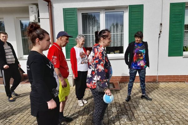 Mieszkańcy korzystają z grilla na tarasuie,tańczą,  grają w kręgle , częstują się kiełbaską.