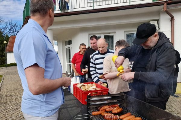 Mieszkańcy korzystają z grilla na tarasuie,tańczą,  grają w kręgle , częstują się kiełbaską.