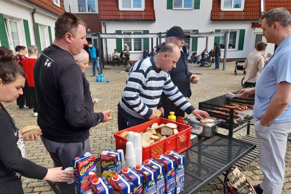 Mieszkańcy korzystają z grilla na tarasuie,tańczą,  grają w kręgle , częstują się kiełbaską.