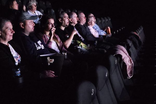 Mieszkańcy siedzą w kinie.