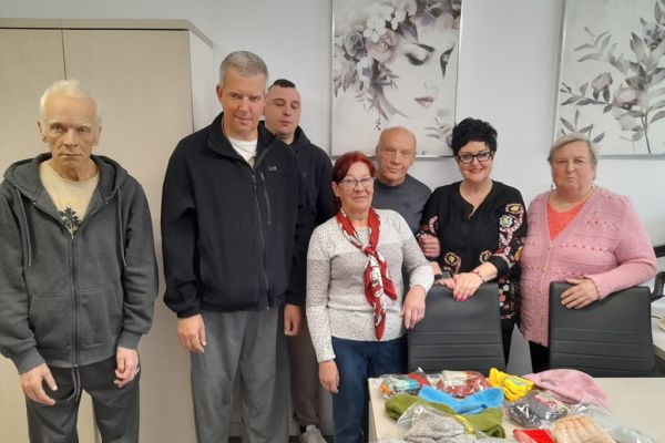 Dwie Panie z podarkami, Mieszkańcy i Pani Dyrektor stoją przy podarunkach położonych na stole.
