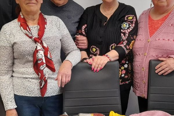 Dwie Panie z podarkami i  Pani Dyrektor stoją przy podarunkach położonych na stole.