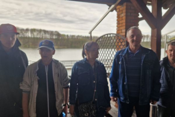 Mieszkańcy stoja a w tle jezioro.