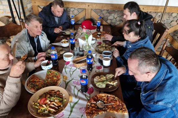 Mieszkańcy siedzą w restauracji przy stoliku.