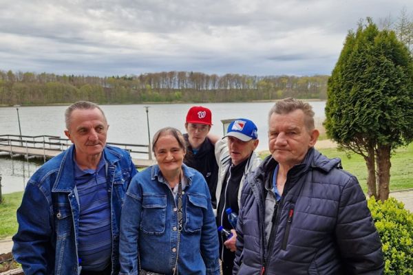 Mieszkańcy stoja a w tle jezioro.