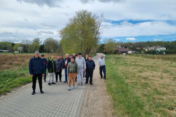 Mieszkańcy idą drogą we wsi.