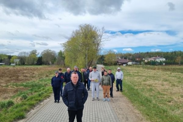 Mieszkańcy idą drogą we wsi.