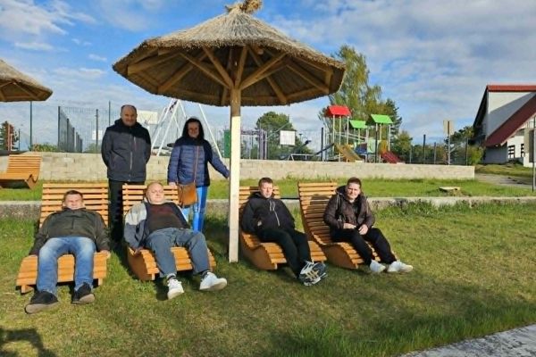 Mieszkańcy leżą na leżakach.