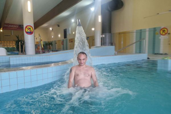 Mieszkaniec kąpie się w wodzie na basenie.