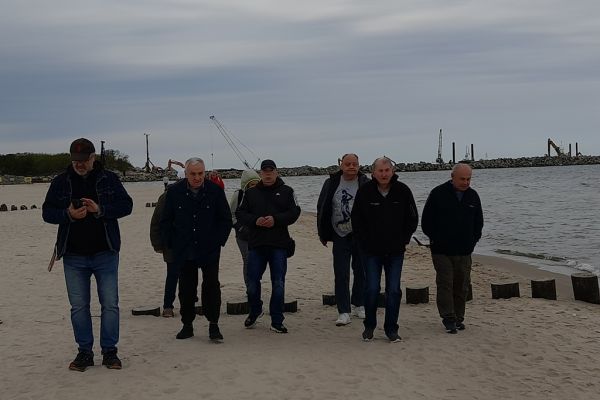 Mieszkańcy idą po plaży.