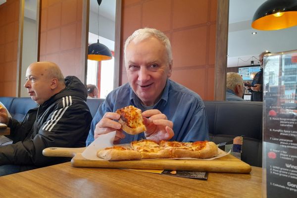 Mieszkaniec je pizze.