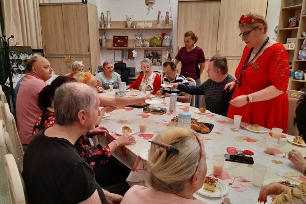 Mieszkańcy częstują się upieczonym ciastem.