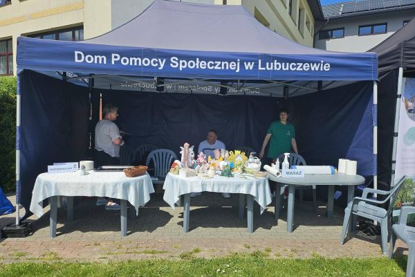 Namiot DPS a w nim pracownicy z wystawą prac mieszkańców.