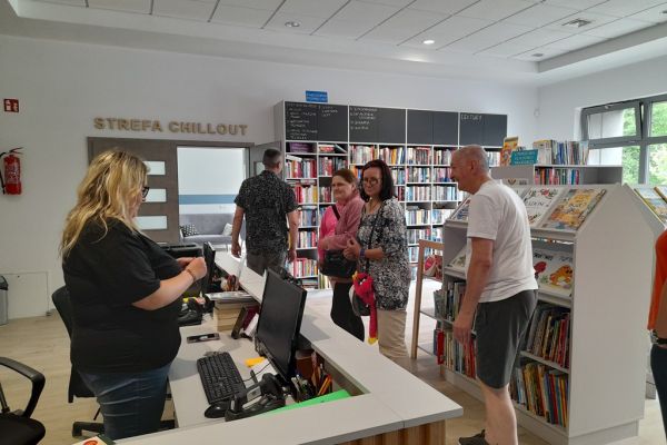 Grupa mieszkańców w bibliotece.