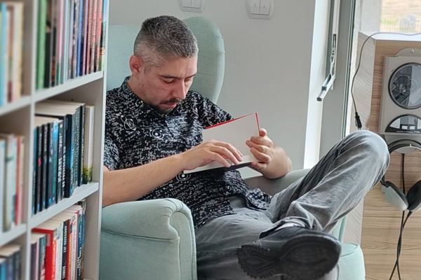 Mieszkaniec czyta książkę przy stoliku.