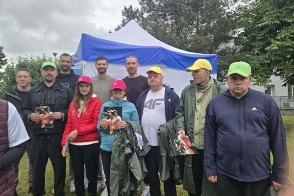 Grupowe zdjęcie mieszkańców ze znanymi sportowcami.