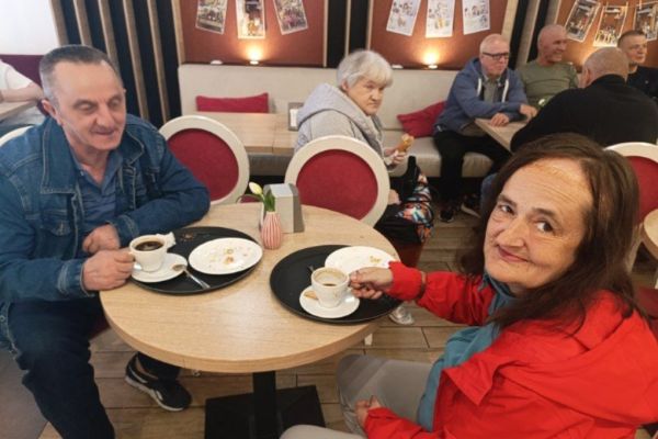 Mieszkańcy siedzą w restauracji i piją kawę.