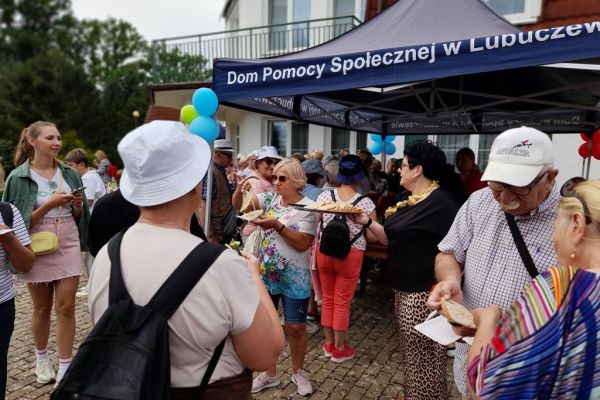 Goście przy namiocie z poczęstunkiem.