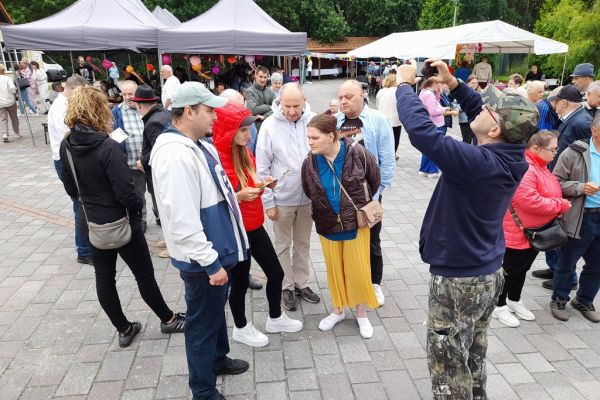 Mieszkańcy stoja na pikniku.