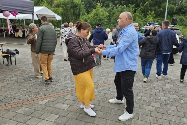 Mieszkańcy tańcza na dworze.
