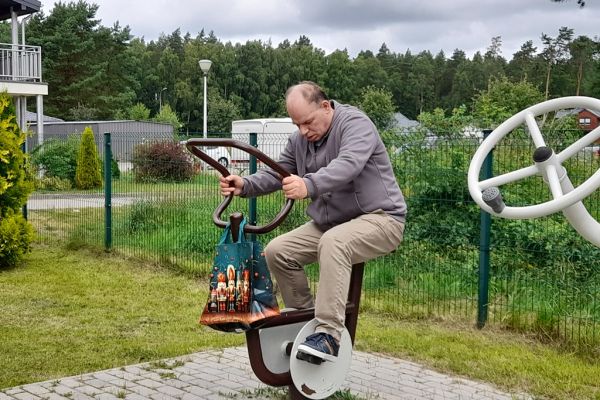 Mieszkaniec na rowerku na siłowni zewnętrznej.