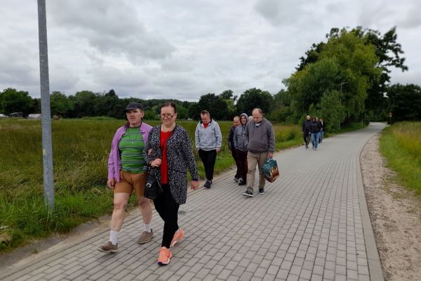 Mieszkańcy ida na spacer drogą we wsi.