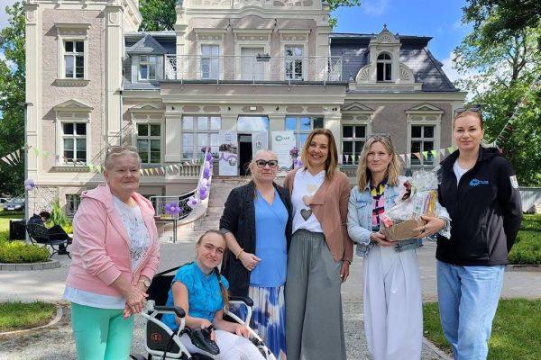  Grupa mieszkańców z prezentem dla kierowniczki CUS.