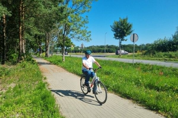 Mieszkaniec na rowerze na ścieżce rowerowej.