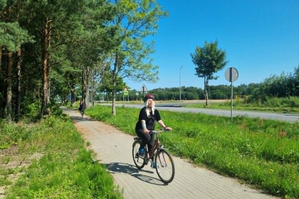 Mieszkanka na rowerze na ścieżce rowerowej.