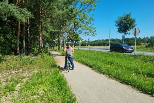 Mieszkaniec na rowerze na ścieżce rowerowej.