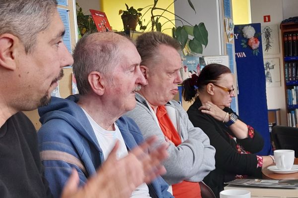 Dyskusja uczestników spotkania przy stolikach.