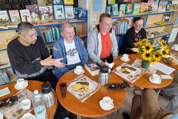 Dyskusja uczestników spotkania przy stolikach.