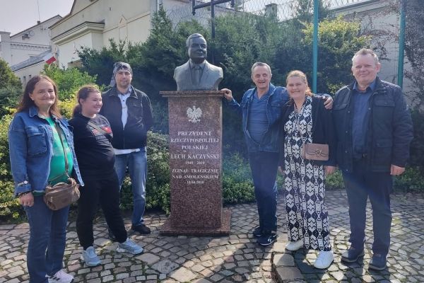 Mieszkańcy stoją przy pomniku.