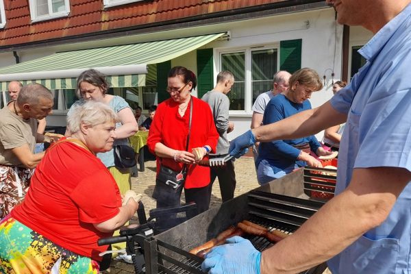 Mieszkańcy częstowani kiełbaską.