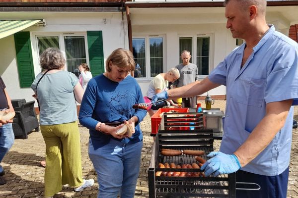 Mieszkańcy częstowani kiełbaską.
