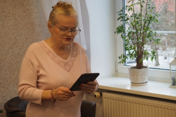 Mieszkanka czyta wiersz z okazji Dnia Babci i Dziadka.