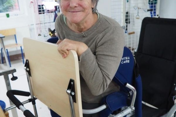 Mieszkanka ćwiczy na sprzęcie do ćwiczeń w sali rehabilitacyjnej.