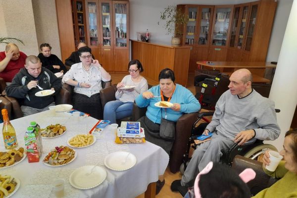 Mieszkańcy świętują uroczyście urodziny przy poczęstunku.