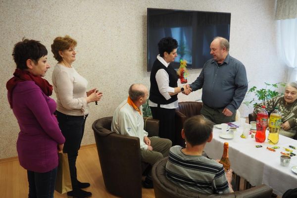 Mieszkańcy świętują uroczyście urodziny przy poczęstunku.