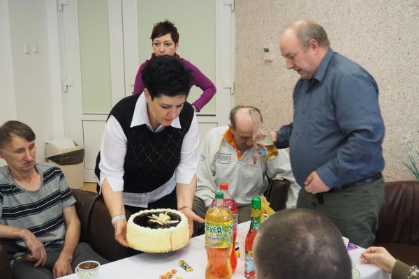 Mieszkańcy świętują uroczyście urodziny przy poczęstunku.
