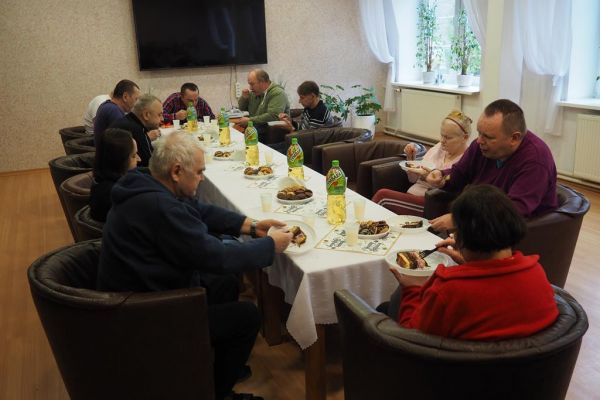 Mieszkańcy świętują uroczyście urodziny przy poczęstunku.