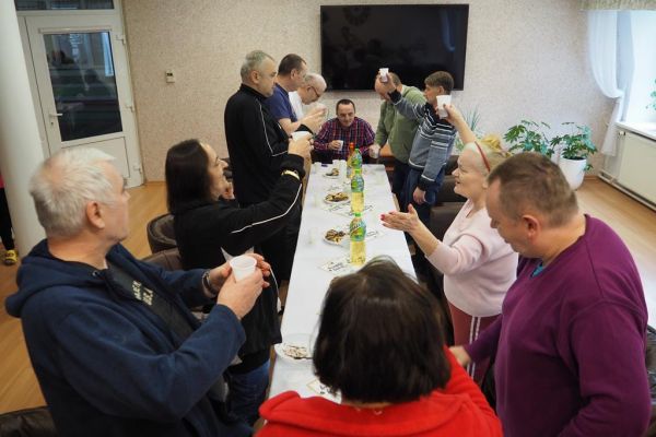 Mieszkańcy świętują uroczyście urodziny przy poczęstunku.