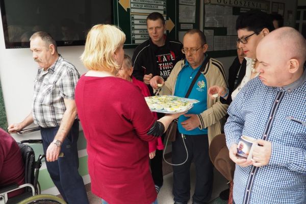 Pracownica dzieli się jajkiem wielkanocnym z Mieszkańcami.