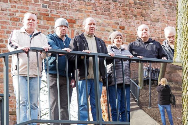 Mieszkańcy stoją przy starym murze obronnym w Słupsku.