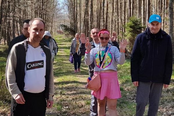 Mieszkańcy idą leśną ścieżką.