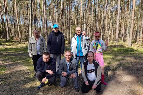 Grupowe zdjęcie Mieszkańców w środku lasu.